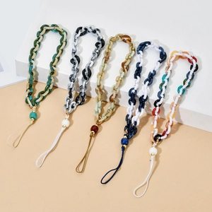 Macro shot of colorful resin acrylic chain phone straps with marble texture on white stands