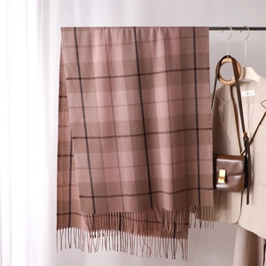 Detailed view of pink and brown plaid pattern fabric and soft tassels on the scarf