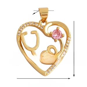 Macro shot of 21mm gold heart stethoscope pendant with white zircons and pink gemstone