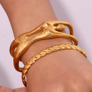 Detail of 18K gold plated artistic female torso cuff and twisted rope bangle set