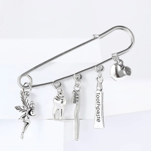 Silver alloy safety pin brooch featuring dentist fairy, tooth and toothpaste pendants
