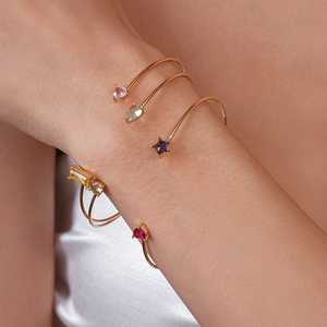 Vue détaillée de joncs dorés avec pierres de zircon colorées en forme de coeur