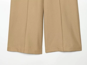 Detail of khaki slim-fit trousers showing high-quality twill fabric and neat hem stitching