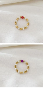 Detailed view of elastic 18K gold beads and freshwater pearl rings with colorful accents