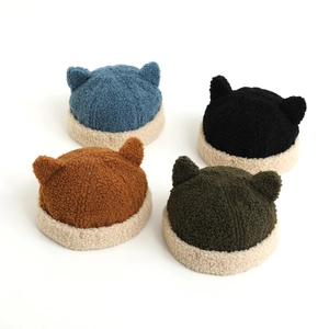 Flat lay of colorful corduroy baby beanies with cute cat ears and beige fleece brims
