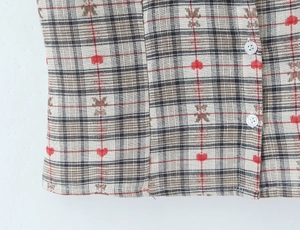 Detail of plaid shirt fabric with bear and heart prints and white buttons