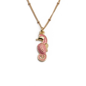 Golden seahorse pendant necklace with pink enamel and sparkling zircon on white background