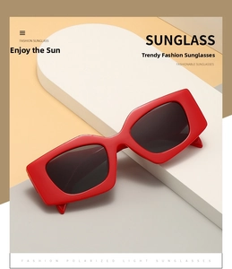 Detail of red rectangular polarized sunglasses with chunky frames on a minimalist display