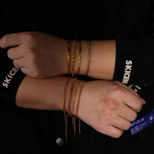 Macro detail of 18K gold-plated stainless steel multi-layered chain bracelets set
