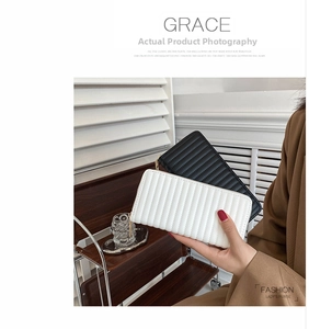 Vertical quilted long PU leather wallet shown in black and white held by a model