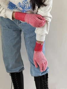 Detalle de guantes de punto a rayas rojas y rosas con puños extendidos a prueba de viento