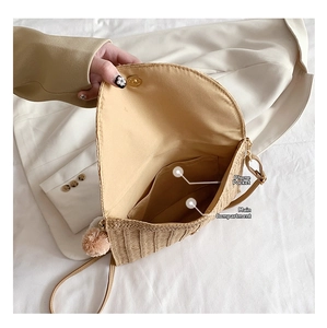 Detail view of woven straw bag interior showing main compartment and phone pocket