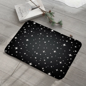 Detail of black rectangular door mat with white star patterns on grey wooden floor