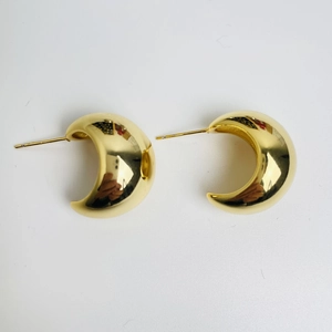 Detailed view of chunky C-shaped crescent hoop earrings in polished 18K gold plating