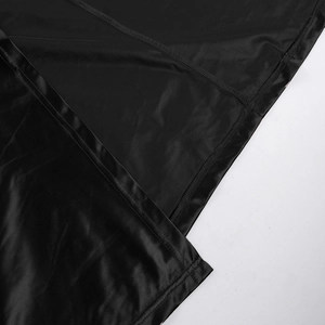 Close-up detail of black satin evening gown fabric with fine stitching and smooth texture