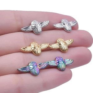 Detailed view of scarab beetle earrings in silver, gold, and rainbow iridescent finish