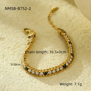 Detailed close-up of golden double-chain bracelet with green gems and white zircons