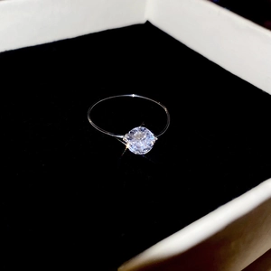 Macro detail of a large round zircon stone on a slim silver band in a jewelry box