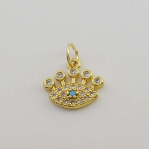 Macro detail of 18K gold plated Evil Eye pendant with pavé zircons and a blue center stone