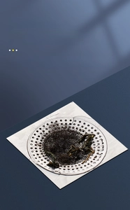 Close-up of stainless steel square floor drain strainer with round mesh for hair filtering