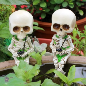 Detailed close-up of two skeleton figurines fishing with moss accents in a garden