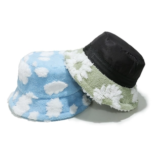 Detailed view of plush teddy velvet bucket hats with white cloud texture in blue and green