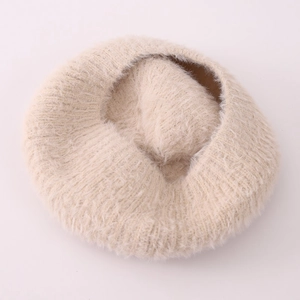 Détail de la texture en fausse fourrure crème douce d'un béret d'hiver pour petites filles