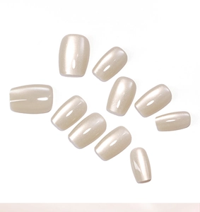 Détail macro de 10 faux ongles champagne œil-de-chat avec une finition nacrée scintillante