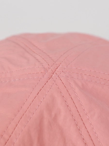 Vista macro della corona di un cappellino in nylon rosa con cuciture a sei pannelli