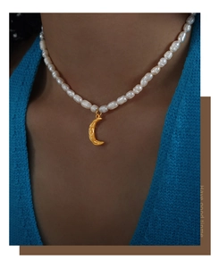Detailed view of textured gold moon pendant with natural freshwater pearls on a necklace