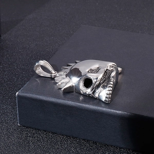 Macro shot of silver gothic skull pendant with detailed mechanical gear gears and a polished finish