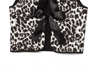 Detailed close-up of quilted leopard print vest featuring elegant black satin bow ties