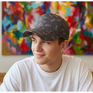 Detail of dark grey baseball cap featuring gold logo print and AR letter embroidery