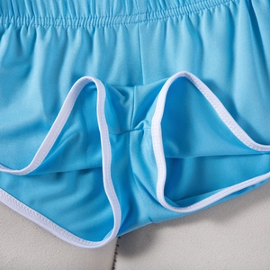 Detailaufnahme der blauen Sporthose mit weißem Saum und atmungsaktiver Netzstruktur