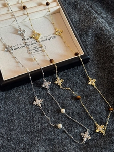 Détails des pendentifs croix en œil de tigre et perles sur d'élégants colliers vintage