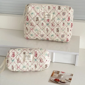 Floral quilted cosmetic bags set with cute animal patterns on a minimal shelf