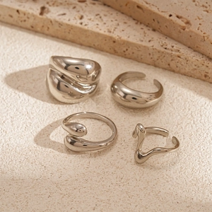 Detailansicht der 4-teiligen silbernen Ring-Kollektion mit flüssigen Metallformen