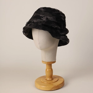 Distressed black bucket hat with raw edge texture on model head with wooden base