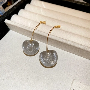 Gros plan de boucles d'oreilles cerises gris pailleté avec crochets dorés élégants