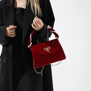 Red velvet evening handbag with gold bow and pearl handle for wedding ceremonies