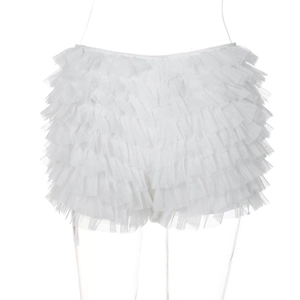 Dettaglio delle balze in pizzo bianco e della trama in mesh su questi pantaloncini