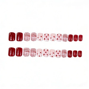Short square glossy press-on nails featuring red heart and stripe designs for Valentine's Day