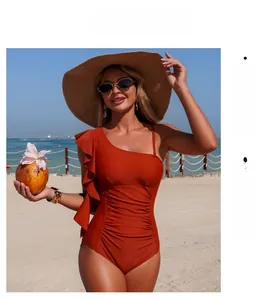 Detail of orange one-shoulder swimsuit with ruffled shoulder and ruched shaping fabric