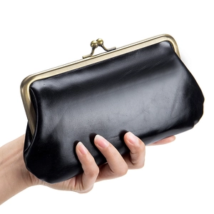 Retro black leather clutch wallet with bronze metal clasp held in hand on white background