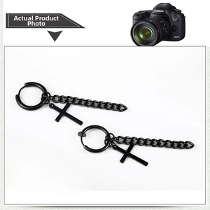 Close-up of black stainless steel hoop earrings with cross pendant and long metal chain