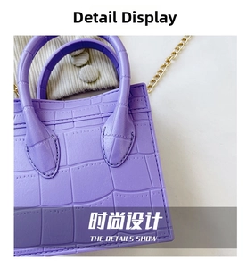 Close-up of purple faux crocodile pattern leather with gold chain detail on fashion bag