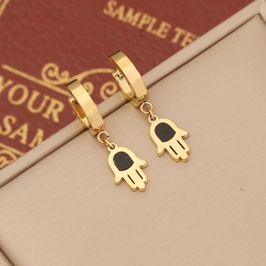 Golden Hamsa hand hook earrings with black center accent on a jewelry box display
