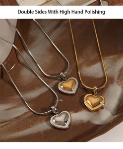 Detail of silver and gold heart pendants on marble tray showing high hand polishing