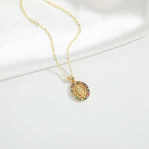 Religious golden necklace with Virgin Mary pendant and colorful zircon stones on white background