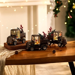 Close-up of vintage bronze LED Christmas truck with Santa scene and snow